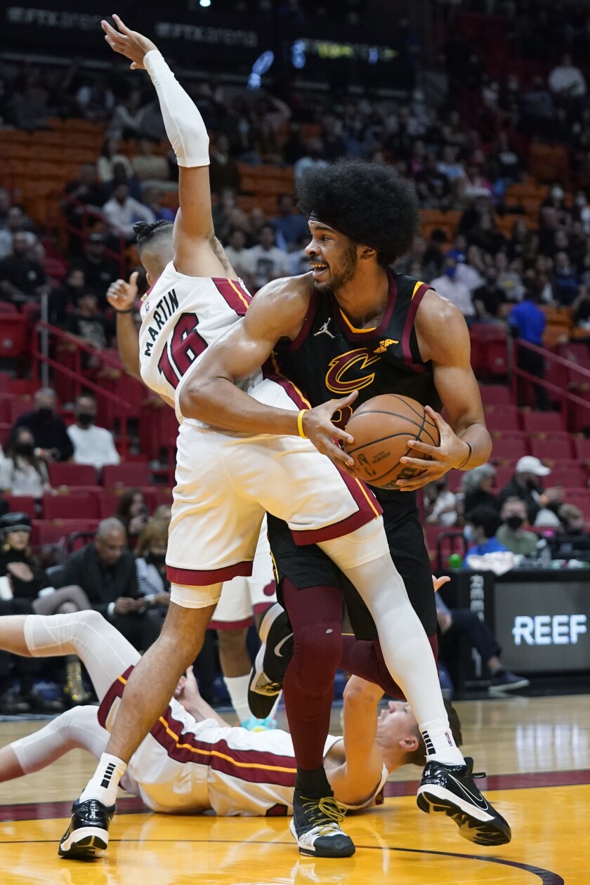 El pívot de los Cavaliers de Cleveland, Jarrett Allen, es defendido por Caleb Martin, del Heat de Miami, en la primera mitad del juego del miércoles 1 de diciembre de 2021, en Miami. (AP Foto/Wilfredo Lee)