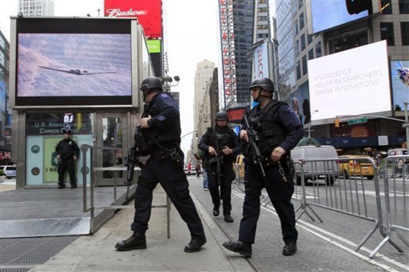 FILE - In this May 2, 2011 file photo, New York City police officers with Operation Hercules arrive at the Armed Forces recruitment center in New York's Times Square. The NYPD has seen a jump in reports of suspicious packages since the president announced the killing of Osama bin Laden, including 62 on Monday, up from 18 a week earlier. All were false alarms, which police officials say have become a frequent but necessary annoyance for authorities laboring to protect a nervous city in the post-9/11 world. (AP Photo/Mary Altaffer, File)