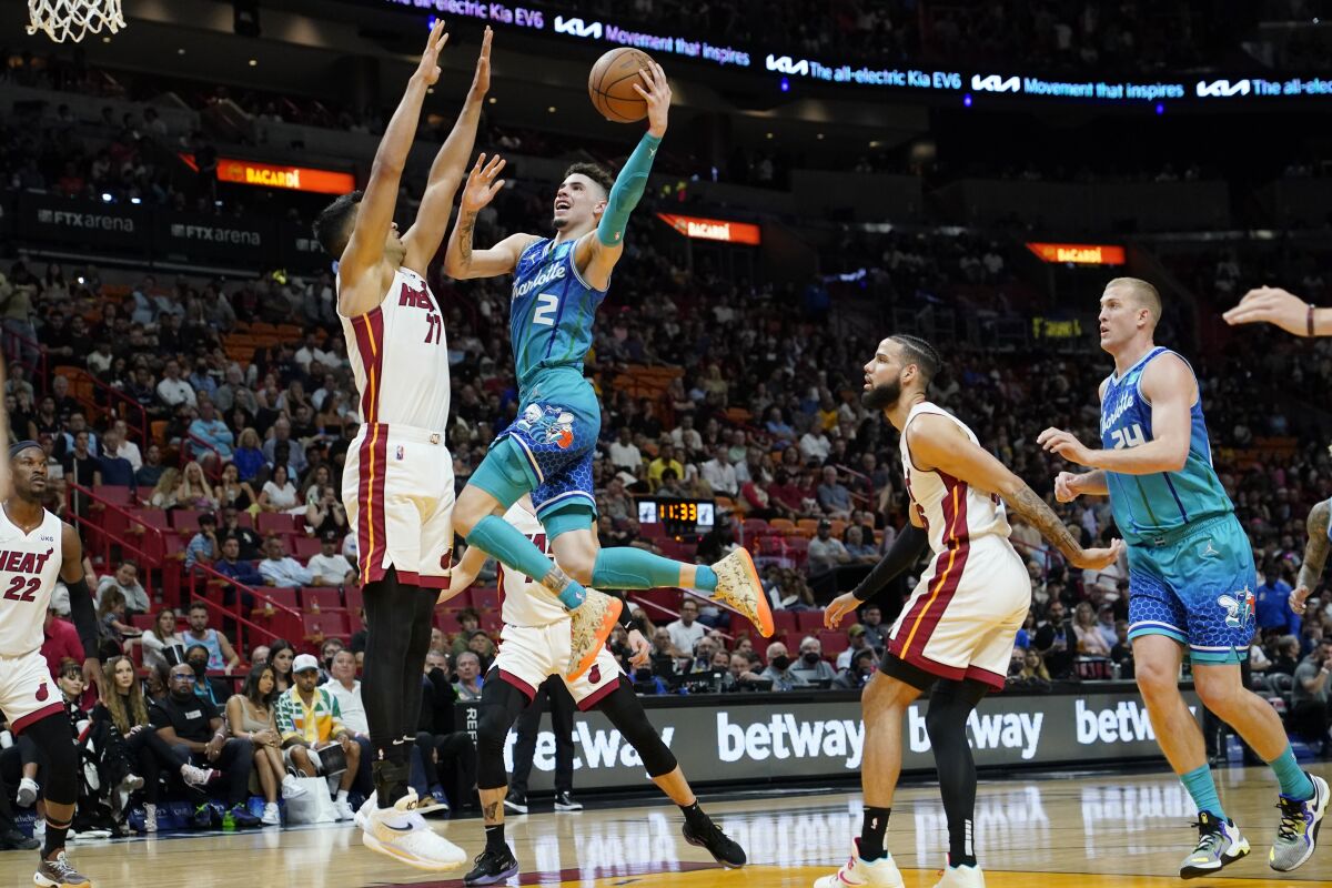 Charlotte Hornets guard LaMelo Ball (2) goes to the basket as Miami Heat center Omer Yurtseven (77) defends during the first half of an NBA basketball game, Tuesday, April 5, 2022, in Miami. (AP Photo/Lynne Sladky)