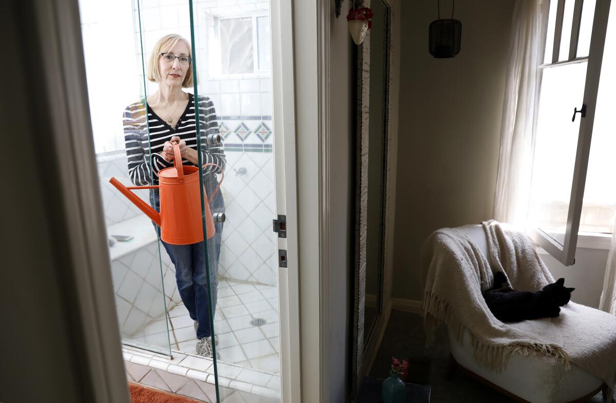 Environmentalist Zan Dubin-Scott has started placing a watering can in her shower to capture the water as it heats up