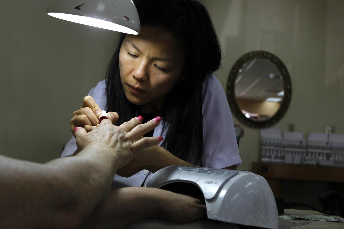 Thuy Vo polishes nails at Queen Nails in Brea in 2012.