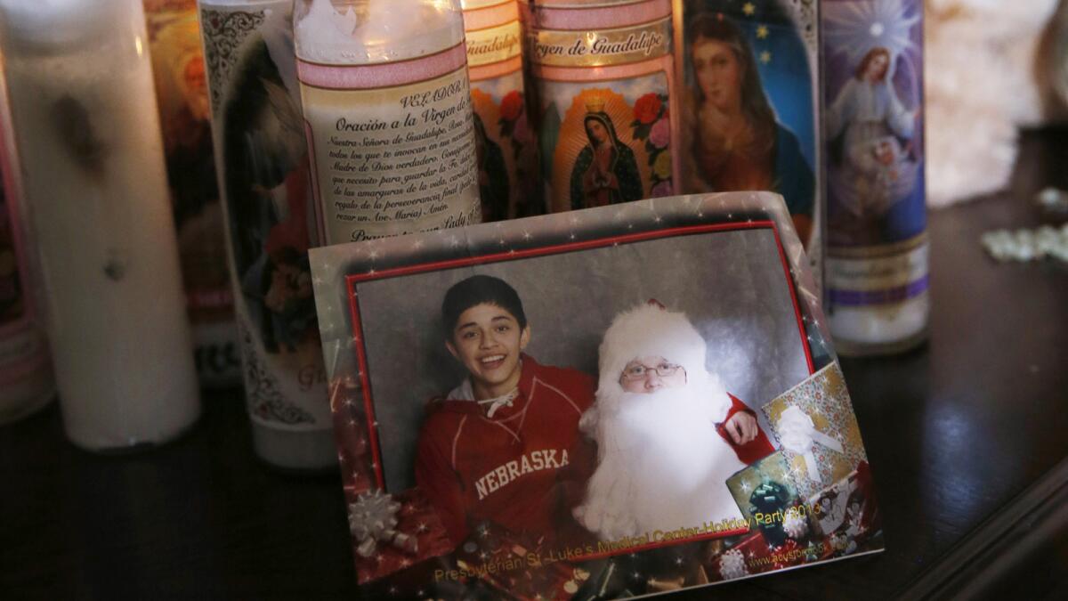 As votive candles burn in the background, a photograph of Jessica Hernandez and Santa Claus sits on a table in her Thornton, Colo., home. Police say Hernandez, 17, was shot and killed by officers after she attempted to run over officers with a stolen car.