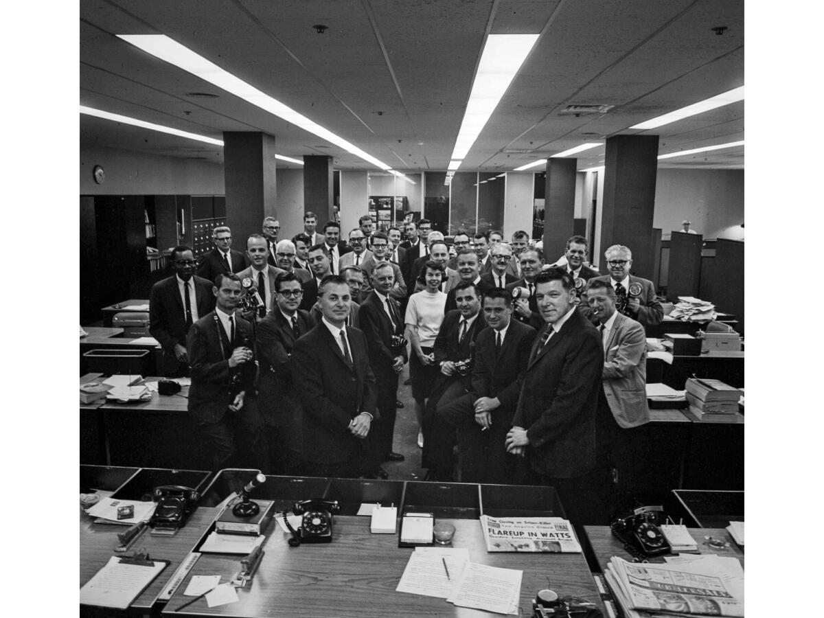 May 2, 1966: Members of the Los Angeles Times' Watts riots coverage team pose in newsroom after winnng the 1966 Pulitzer Prize for local reporting. Times editor Bill Thomas is center left with hands clasped.