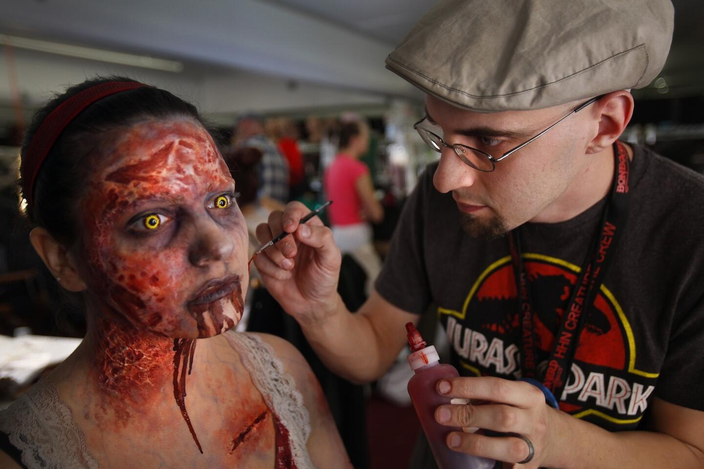 Makeup artist John Wrightson works to transform Aly Marianelli into "Forest Demon Mia" for Universal Studios' "Halloween Horror Nights." Hundreds of people are made up each night with various prosthetics, airbrushing and costumes before they attempt to scare people inside a variety of mazes.