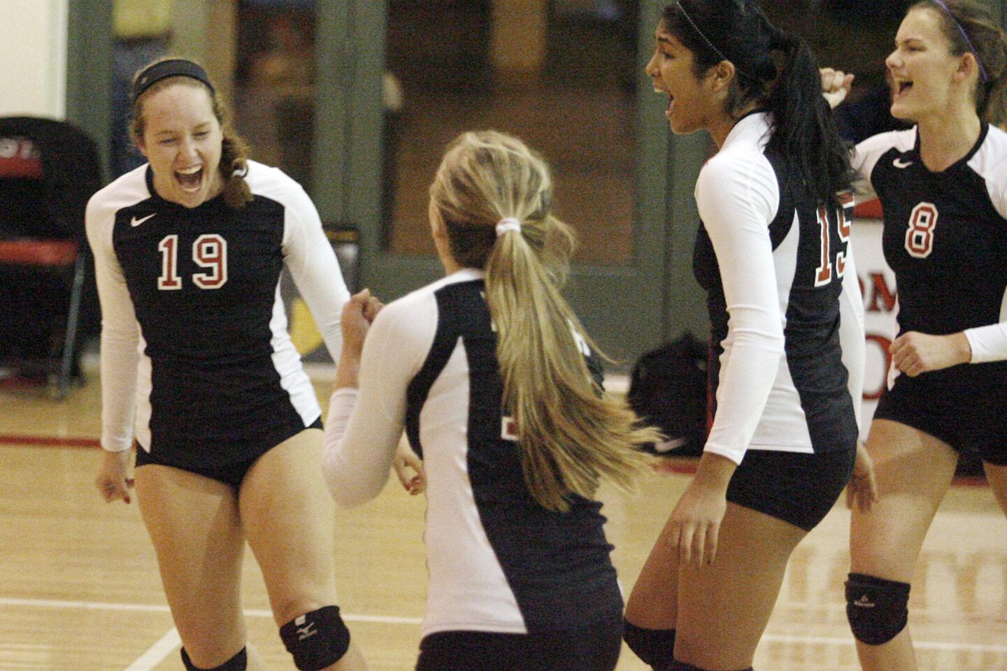 FSHA's Dana Carney, left, rejoices with her teammates after making a point during a game against Chaminade at Flintridge Sacred Heart Academy in La Canada on Thursday, October 11, 2012.