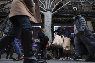 Compradores cargan bolsas en la Quinta Avenida, en Nueva York, el 25 de noviembre de 2022. (AP Foto/Julia Nikhinson)