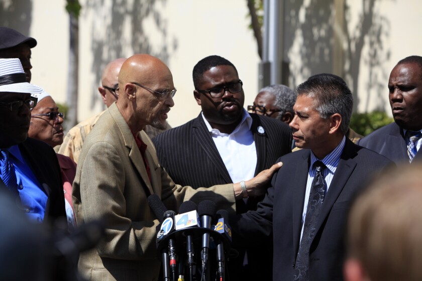 Activist Earl Ofari Hutchinson, left, and California Highway Patrol Commissioner Joseph A. Farrow, right, hold a news conference together after discussing issues involved in the beating of a woman on a Los Angeles freeway that was recorded on video.