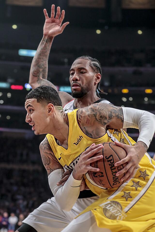 Lakers forward Kyle Kuzma is guarded by Clippers forward Kawhi Leonard on a drive to the basket during the first half.