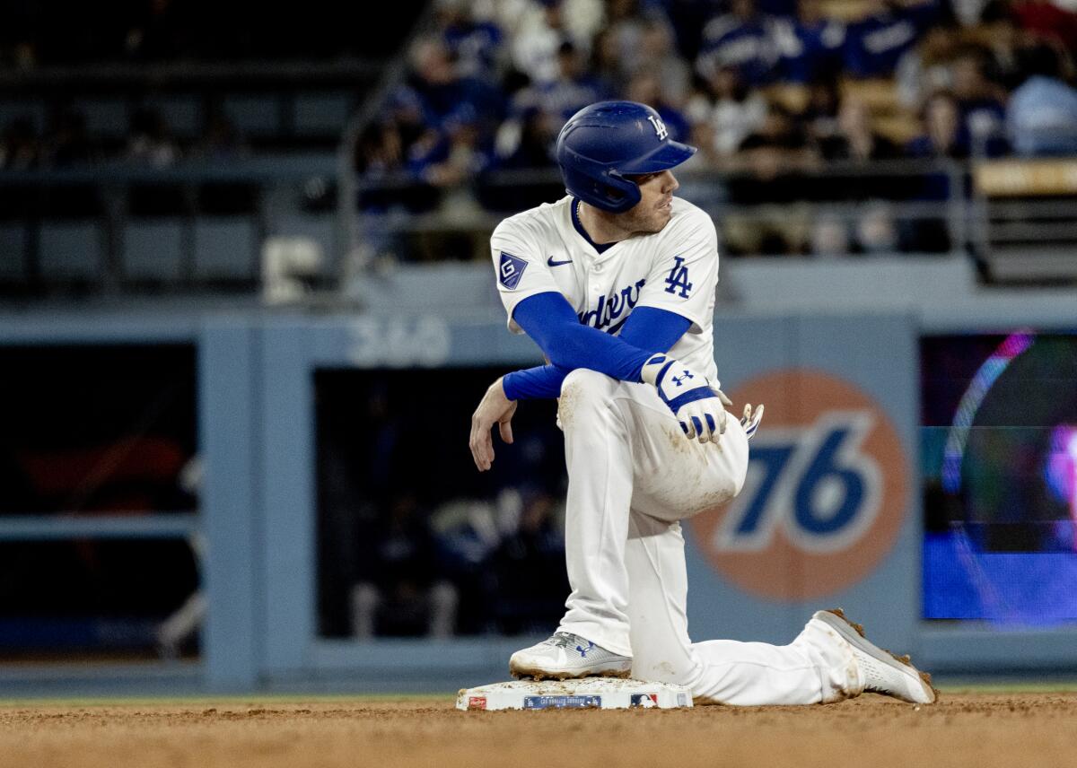Dodgers' Freddie Freeman kneels at second base during a review after hitting a double at Dodger Stadium