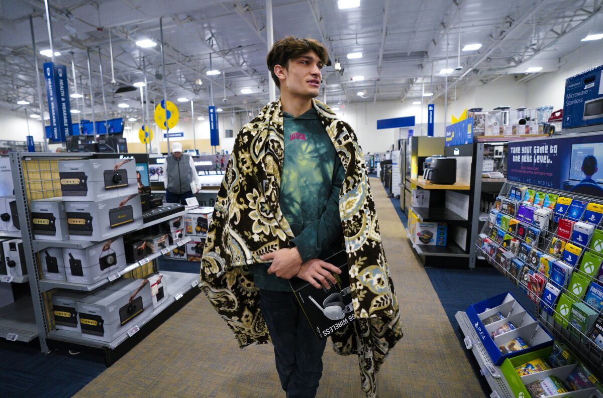 Alex Escobar used a blanket to stay warm while shopping at Best Buy.