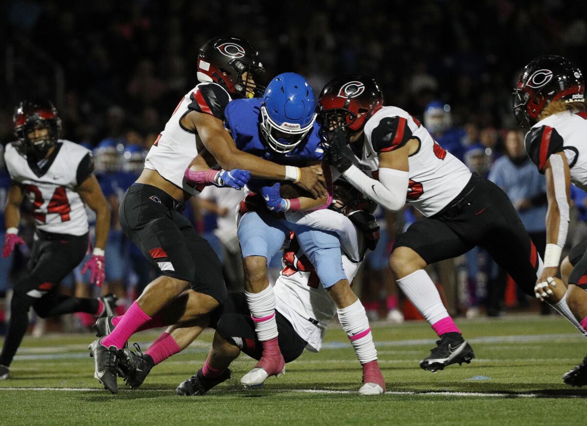 It takes three Corona Centennial defenders to bring down Norco wide receiver Grant Gray.