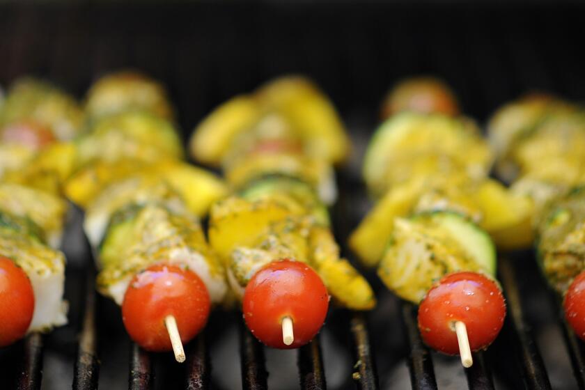 Wine importer Didier Pariente places swordfish kabobs brushed with Chermoula sauce on the grill while cooking a Moroccan lunch with wine pairings at his in-laws' home in Los Angeles on Monday, June 15, 2015.