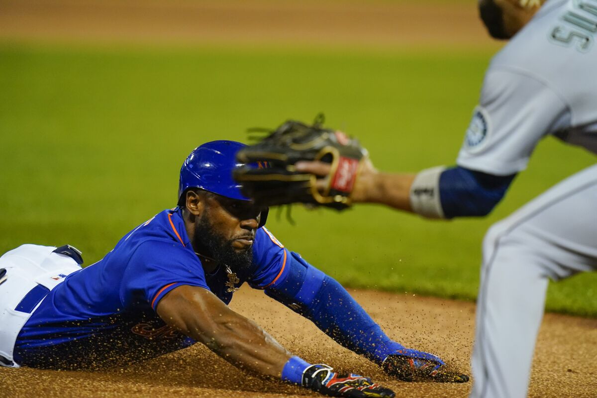 New York Mets' Starling Marte slides to third base during the first inning of a baseball game against the Seattle Mariners, Saturday, May 14, 2022, in New York. After review, Marte was called safe at third for a triple. (AP Photo/Frank Franklin II)