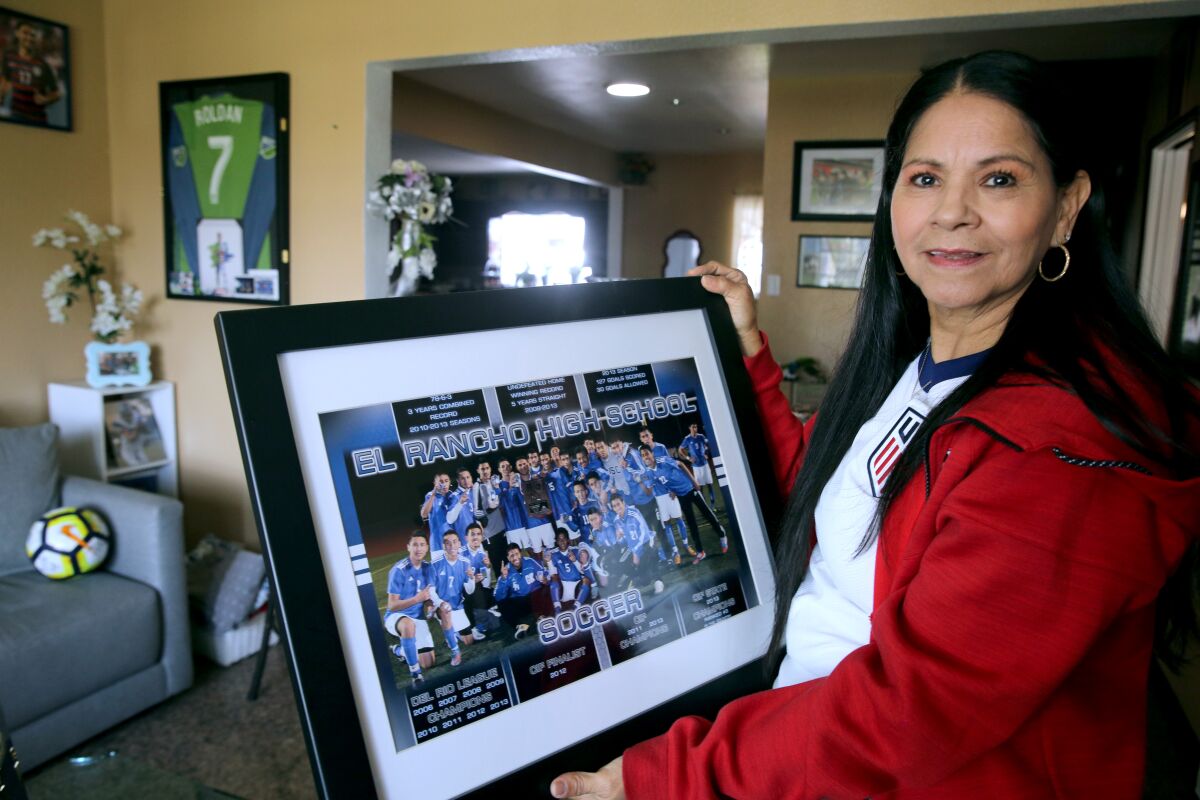 Ana Roldán, originaria de El Salvador, sostiene una foto del equipo campeón de El Rancho High School.