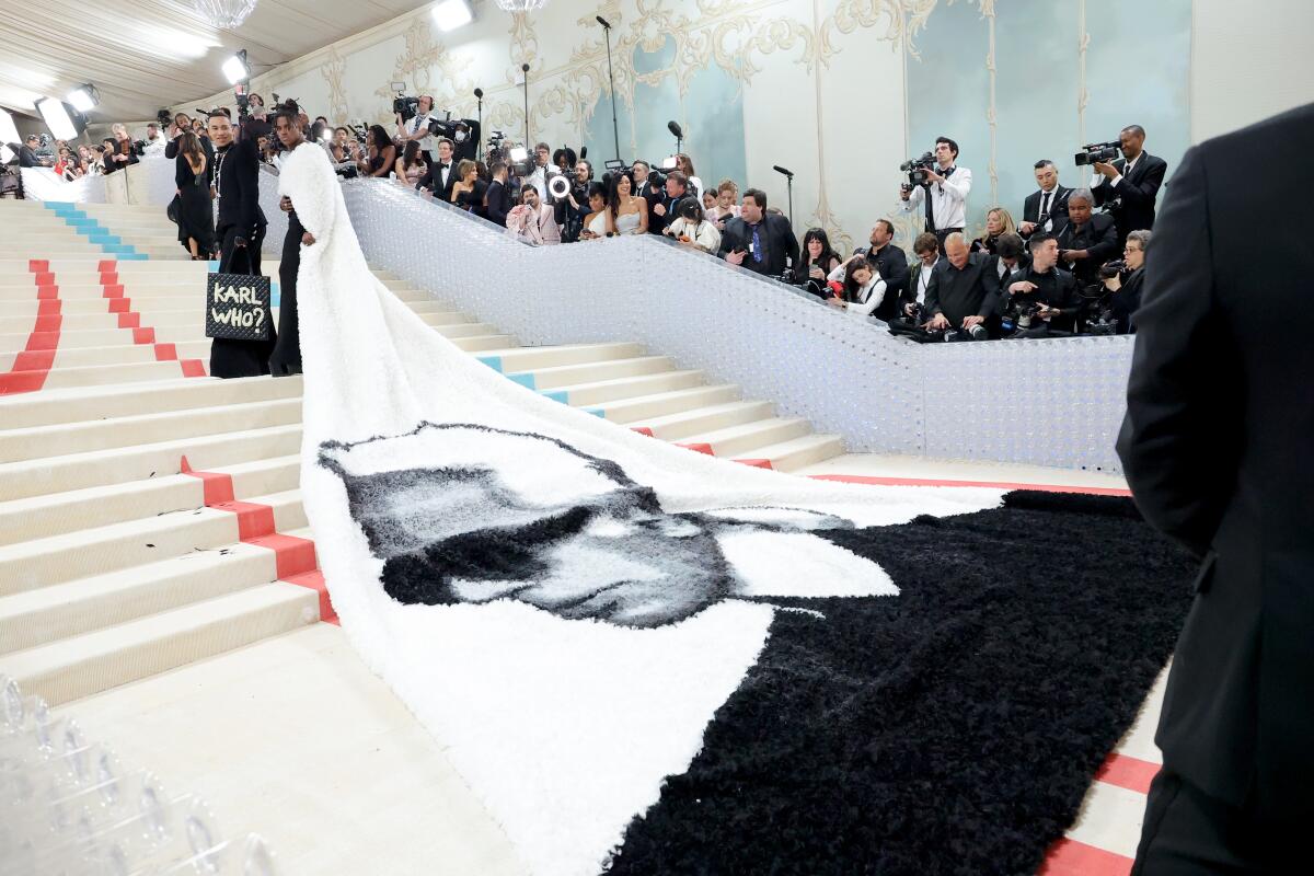 Jeremy Pope wears a white cape with Karl Lagerfeld's face on the train.