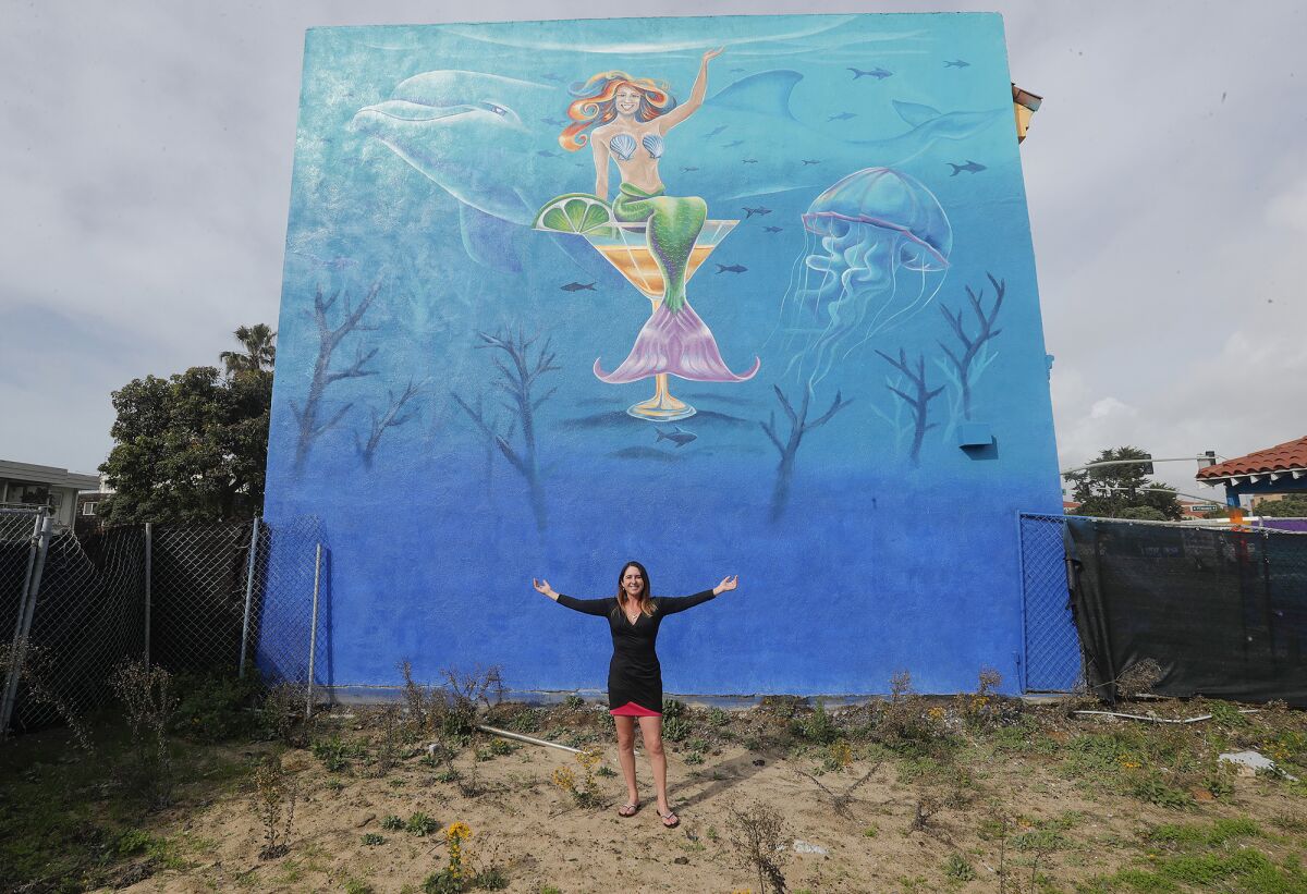 Huntington Beach's Melissa Murphy shows one of her murals at the Sunset Lounge in Sunset Beach.