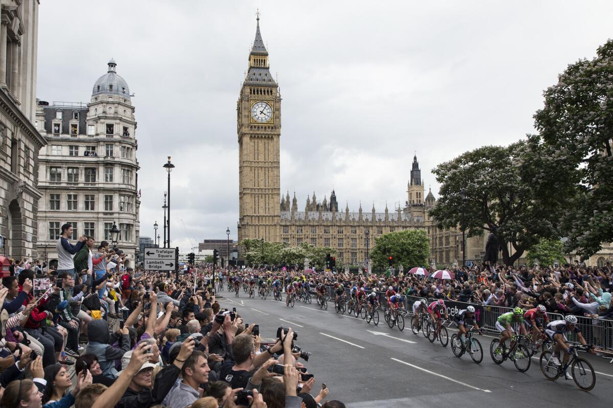 Crowds cheer as cyclists competing in the Tour de France, including stage winner Marcel Kittel, right, pass through Parliament Square at the end of the race's third stage Monday in London.