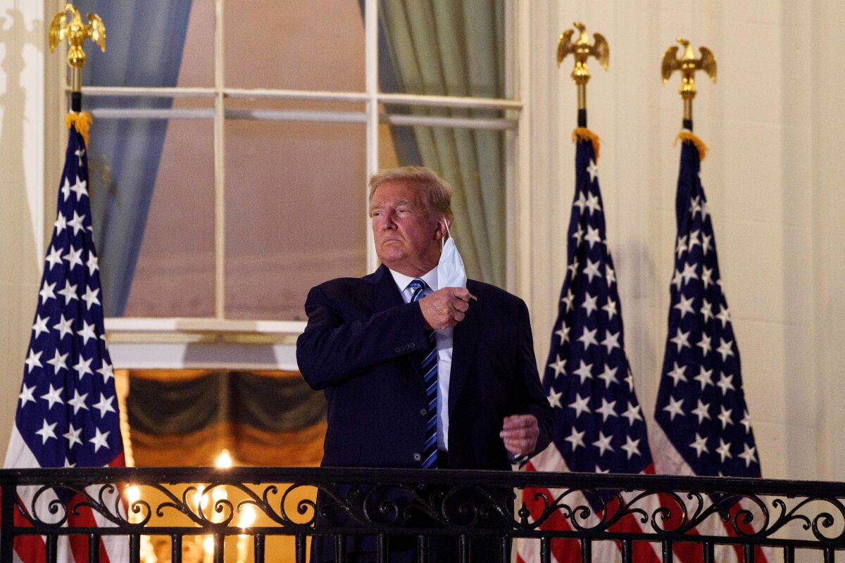 President Trump rips off his mask on a balcony at the White House after returning from the hospital