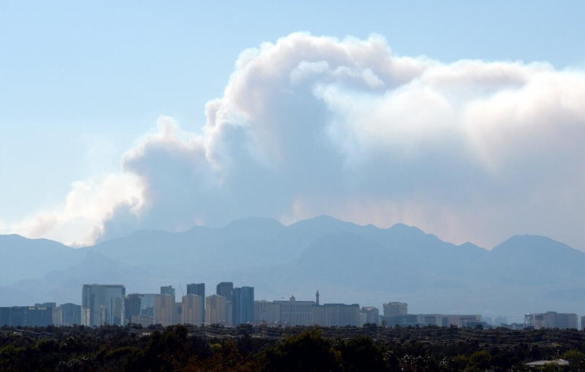 Smoke from the Carpenter 1 fire in the Spring Mountains billows behind the Las Vegas Strip on Tuesday.