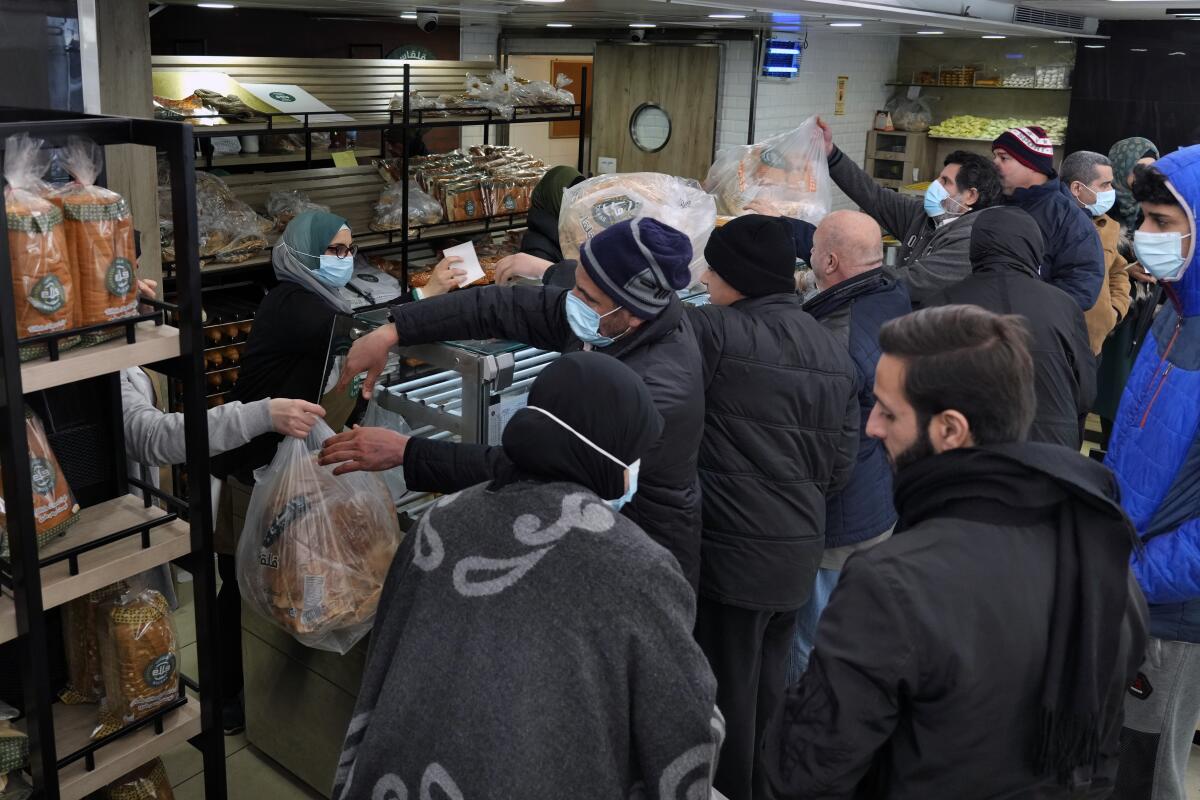 Varias personas hacen una fila para comprar pan en el suburbio de Dahiyeh, en Líbano