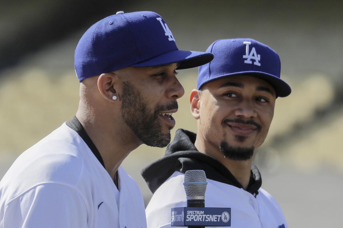 Dodgers pitcher David Price, left, sits next to Mookie Betts while speaking at a news conference.