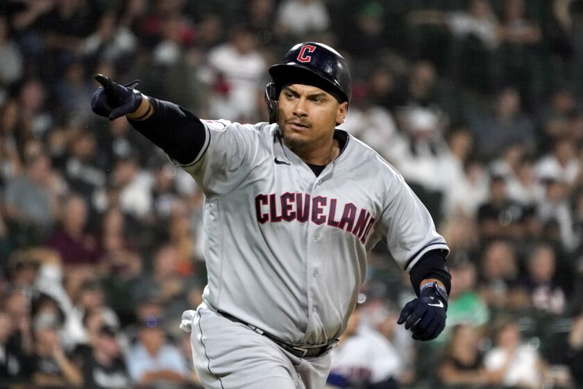 Cleveland Guardians' Josh Naylor points to teammates in the dugout after hitting an RBI single off Chicago White Sox relief pitcher Kendall Graveman during the10th inning of a baseball game Tuesday, Sept. 20, 2022, in Chicago. (AP Photo/Charles Rex Arbogast)