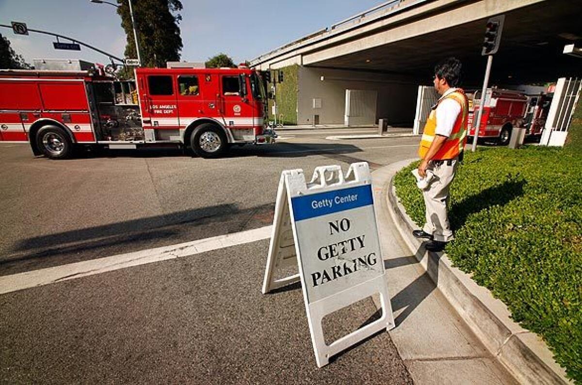 Getty Center employee Mario Cabrera monitors the center's main entrance on Sepulveda Boulevard, which was open only to firefighters.
