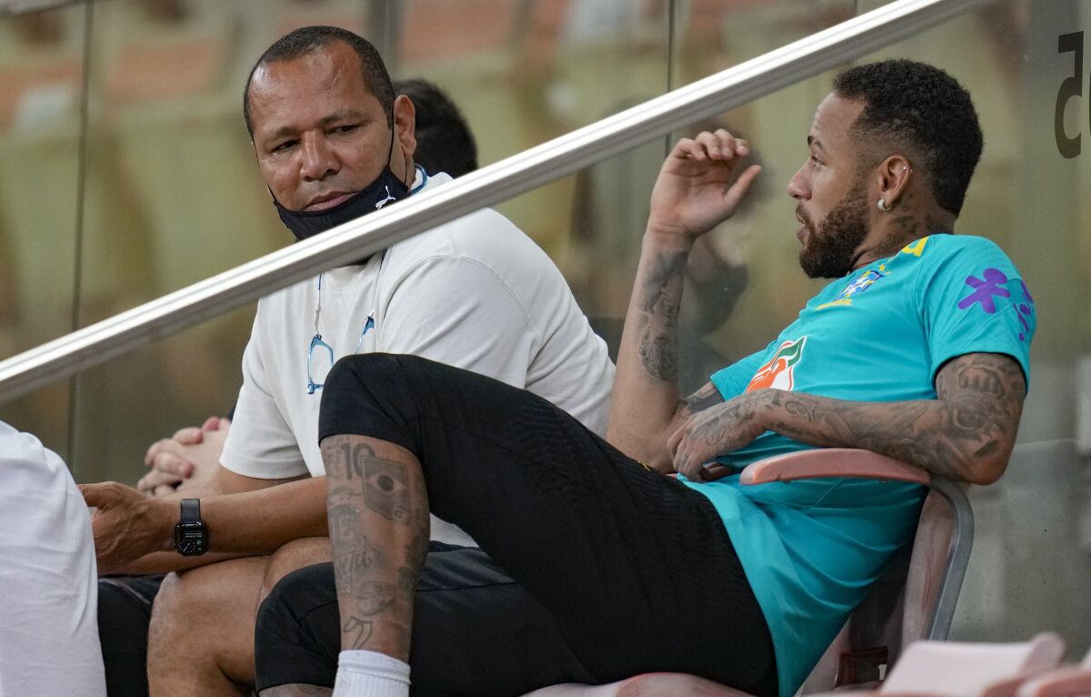 Brazil's Neimar, right, talks with his father Neymar da Silva Santos after a training session in Manaus, Brazil, Wednesday, Oct. 13, 2021. Brazil will face Uruguay in a qualifying soccer match for the FIFA World Cup Qatar 2022 in Manaus on Thursday. (AP Photo/Andre Penner)