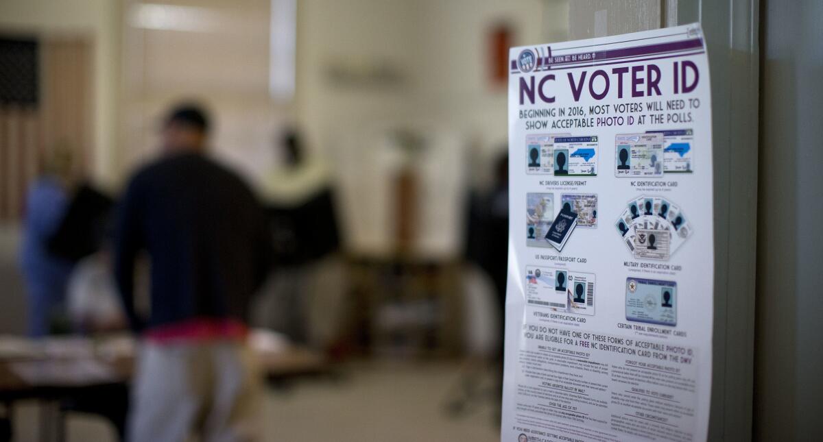 North Carolina voter ID rules are posted at the door of a voting station at the Alamance Fire Station in Greensboro, N.C., on March 15, 2016.