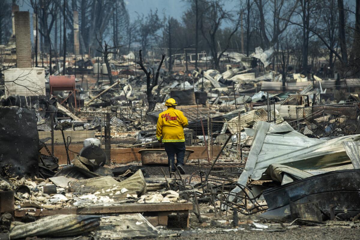 A firefighter walks through debris