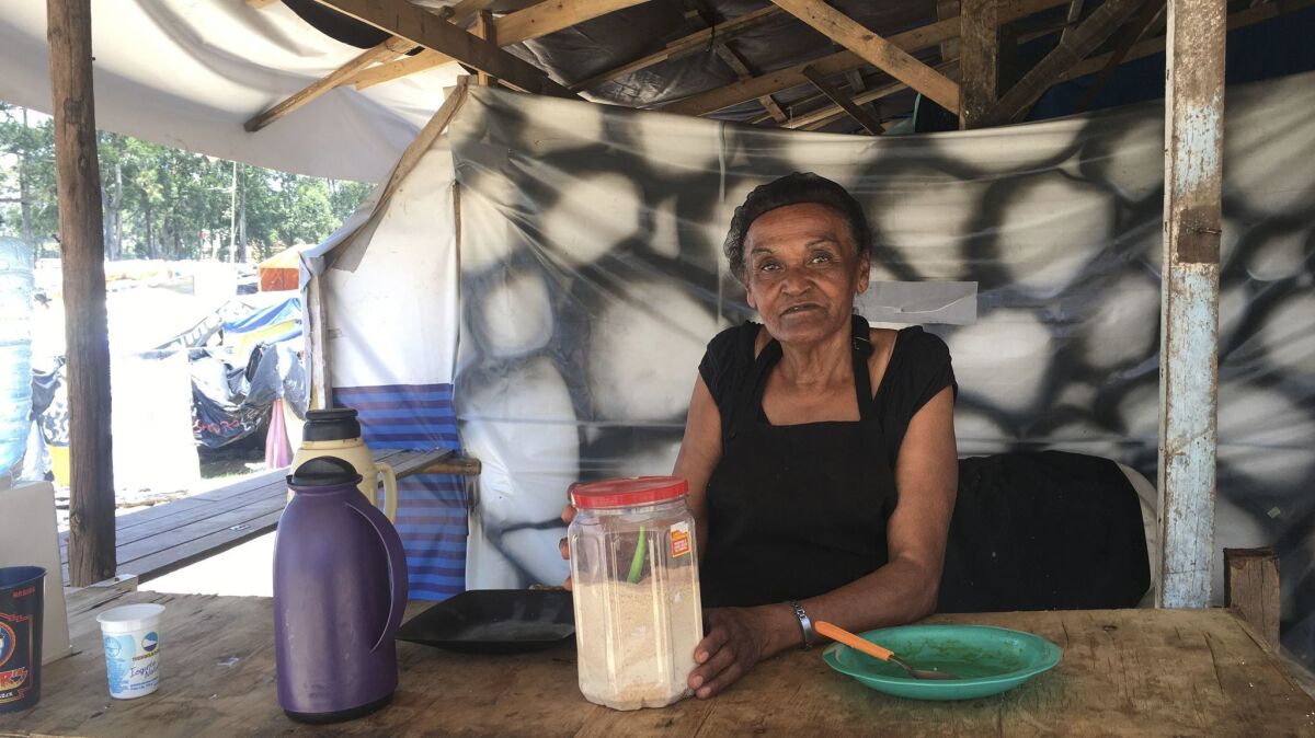 Maria de Almeida Vieira, 63, waits to serve lunch to her neighbors outside the G19 kitchen at the occupation in Sao Bernardo do Campo.