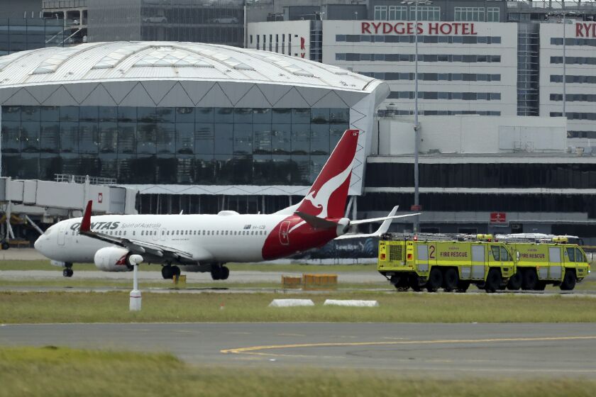 A Qantas jet is parked on the tarmac next to firetrucks at Sydney International Airport after making an emergency landing in Sydney, Wednesday, Jan. 18, 2023. The Qantas flight traveling from New Zealand to Sydney landed safely after it issued a mayday call over the Pacific Ocean. (Jeremy Ng/AAP Image via AP)