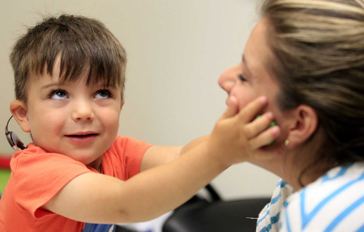 Auguste listens for a series of tones as he participates in the testing of his new ABI device with his mother, Sophie Gareau, and audiologists at USC Center for Childhood Communication.