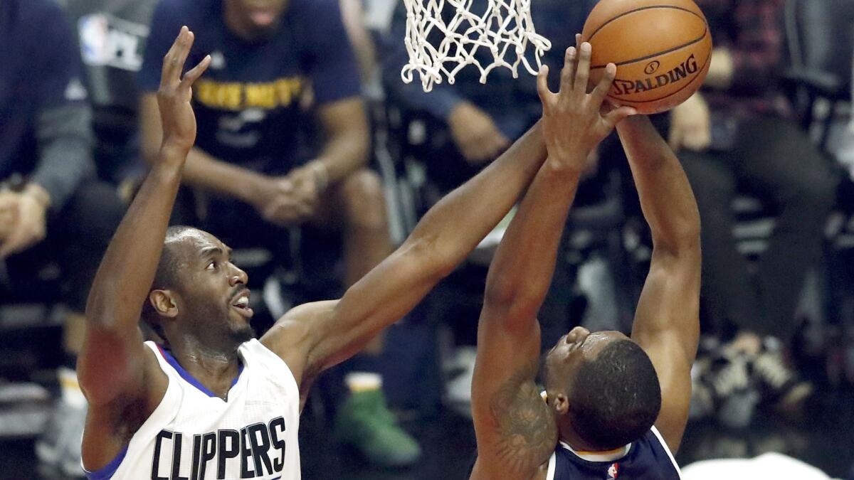 Clippers forward Luc Mbah a Moute of Cameroon blocks a shot by Utah's Derrick Favors on April 15.