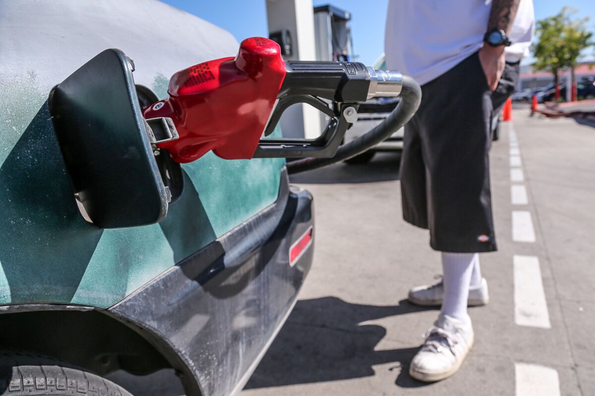 A man fills up his car with gas.