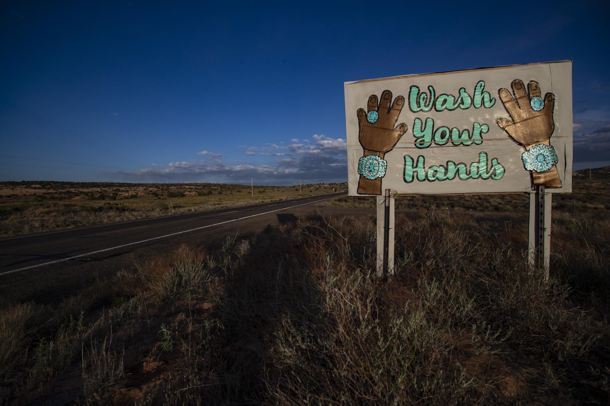 A sign on Highway 98 featuring Navajo turquoise jewelry reads "Wash Your Hands" 