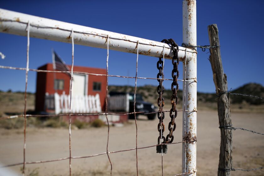 A rusted chain hangs on the fence at the entrance to the Bonanza Creek Ranch film set in Santa Fe, N.M., Wednesday, Oct. 27, 2021. New Mexico authorities said they have recovered a lead projectile believed to have been fired from the gun used in the fatal movie-set shooting. (AP Photo/Andres Leighton)