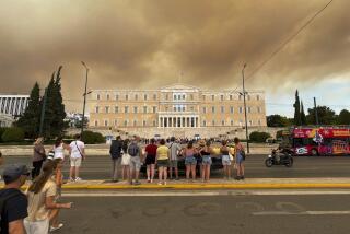 Smoke from wildfires is seen above the Greek parliament building in central Athens, Sunday, Aug. 11, 2024, after a blaze northeast of the capital forced evacuations in the area. (AP Photo/Derek Gatopoulos)