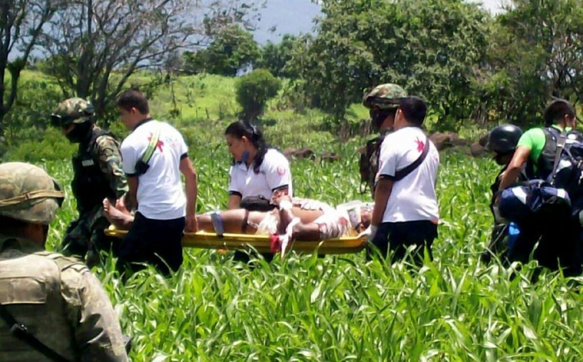 Rescuers carry a wounded victim of an attack on a Mexican navy convoy in Michoacan. Two people were killed, including a vice admiral.