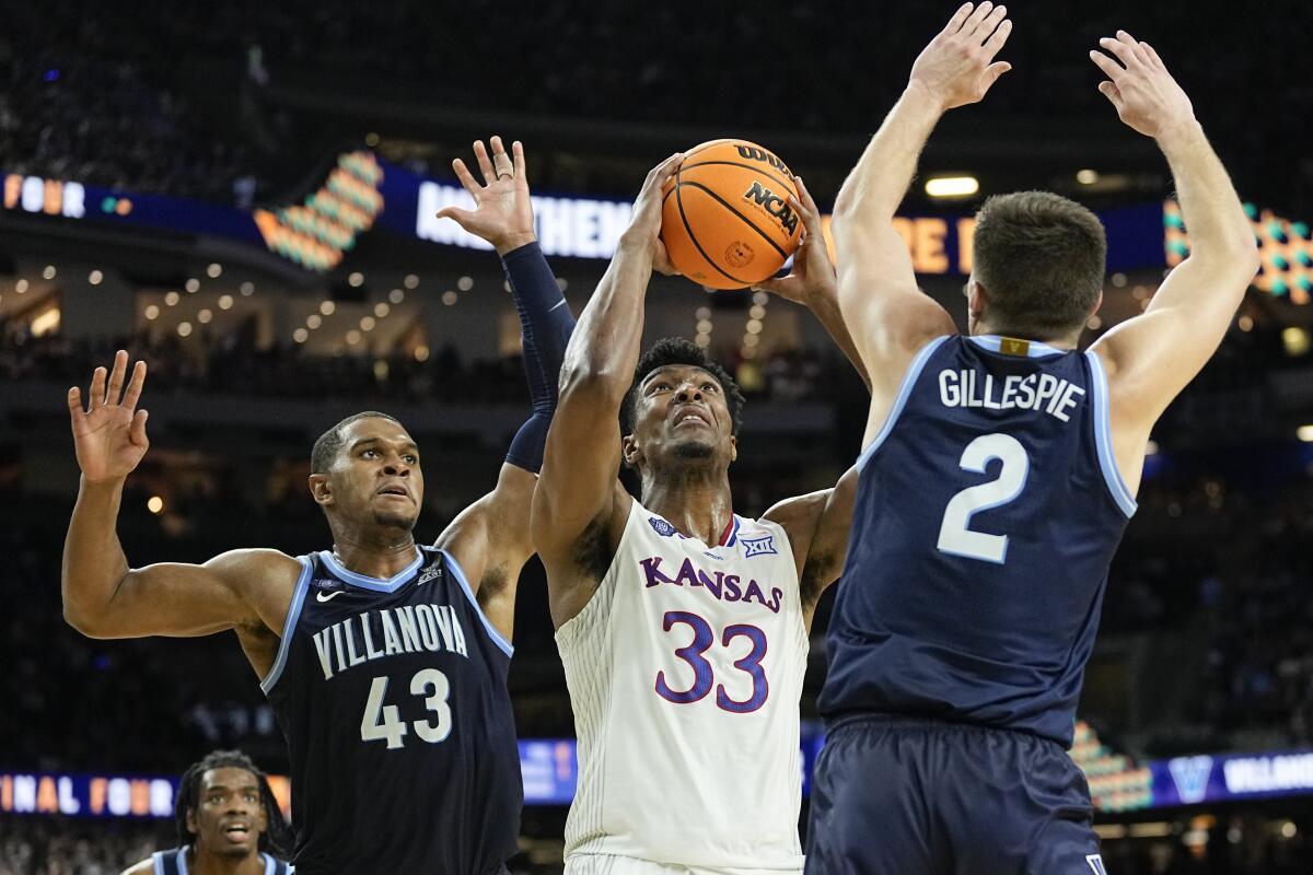 Kansas' David McCormack shoots against Villanova's Eric Dixon, left, and Collin Gillespie on April 2, 2022. 