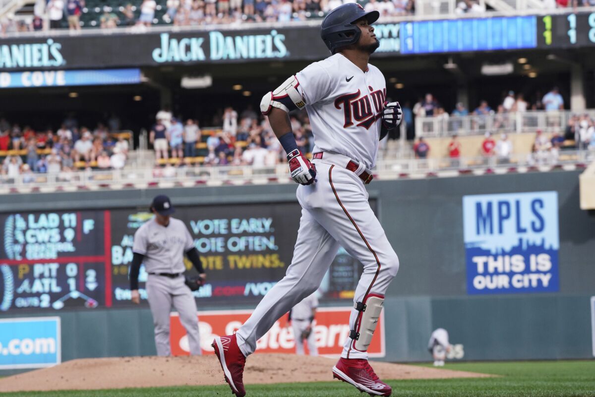 Minnesota Twins' Luis Arraez jogs home on a solo home run off New York Yankees pitcher Gerrit Cole, left, during the first inning of a baseball game, Thursday, June 9, 2022, in Minneapolis. (AP Photo/Jim Mone)