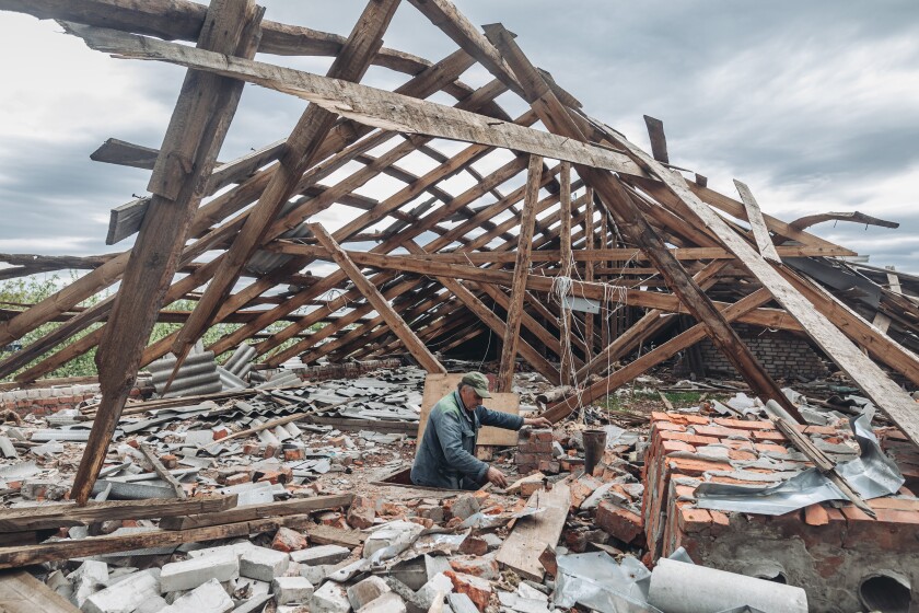A man sifts through rubble in his destroyed home in Ukraine.