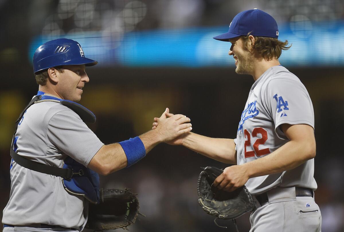 Dodgers pitcher Clayton Kershaw, right, and catcher A.J. Ellis celebrate defeating San Francisco, 5-0, at AT&T Park on Saturday.