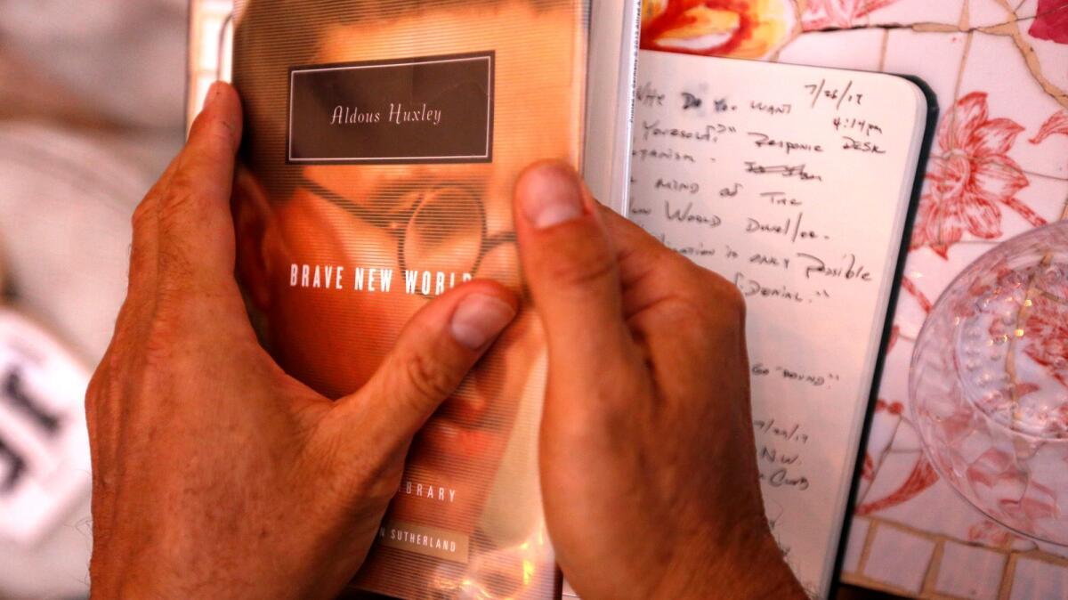 Joshua Levine holds a copy of Aldous Huxley's "Brave New World." (Genaro Molina / Los Angeles Times)