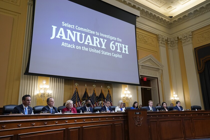 The Jan. 6 House select committee seated below a video screen in the hearing room 