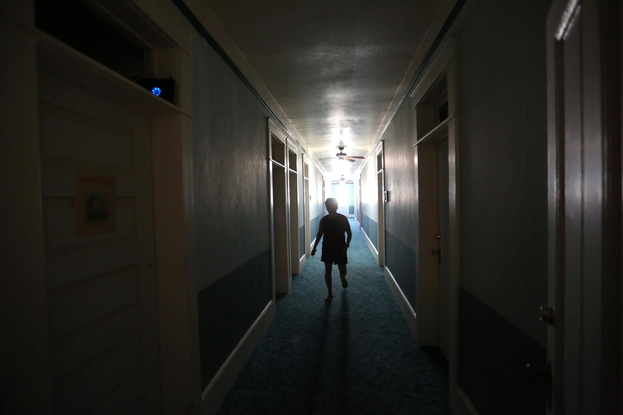 Hotel guest Terri LeDoux walks down a darkened hallway in the historic, and possibly haunted, Niles Hotel.