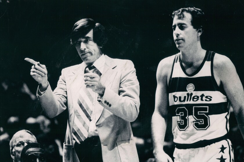 Baltimore Bullets coach Gene Shue motions to the bench in this 1980 photo. At right is Bullets' Kevin Grevey (35). Shue, a two-time NBA Coach of the Year who won 784 games with the Bullets, 76ers and Clippers, has died. He was 90. The Wizards and the NBA announced Shue’s death Monday, April 4, 2021. (Irving H. Phillips Jr./The Baltimore Sun via AP)