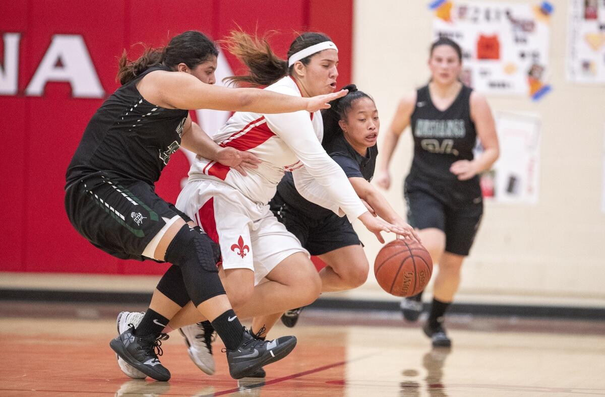 Costa Mesa High's Katie Belmontes, left, and Mary Anna Bijanjan, right, battle for a loose ball with Santa Ana's Esperanza Reyes during an Orange Coast League game on Monday.