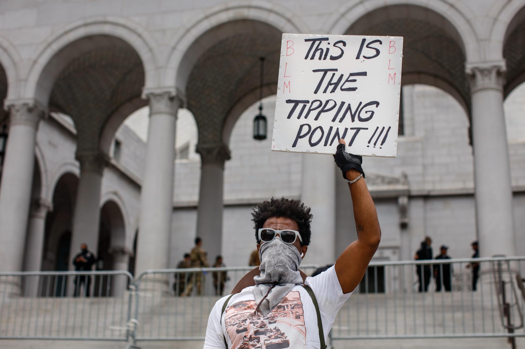 Mek Bitul held up a sign with the words "This Is the Tipping Point!!!" in front of Los Angeles City Hall on June 5, 2020. 
