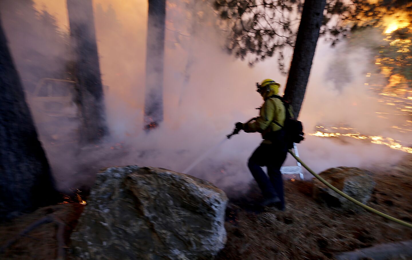 A firefighter battles the Apple fire at the Oak Canyon Conservation Camp near Beaumont.